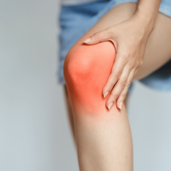 Mujer con dolor que puede acudir a un especialista en rodilla para una artroscopia de rodilla.