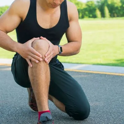 Hombre joven deportista con molestia en rodilla