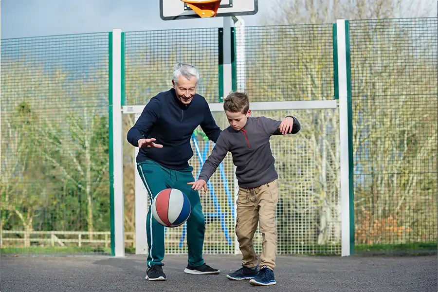 Hombre jugando con niño al baskteball